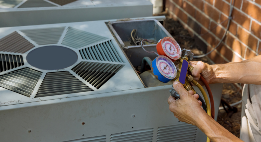 HVAC technician using refrigerant pressure gauges to service an outdoor air conditioning unit